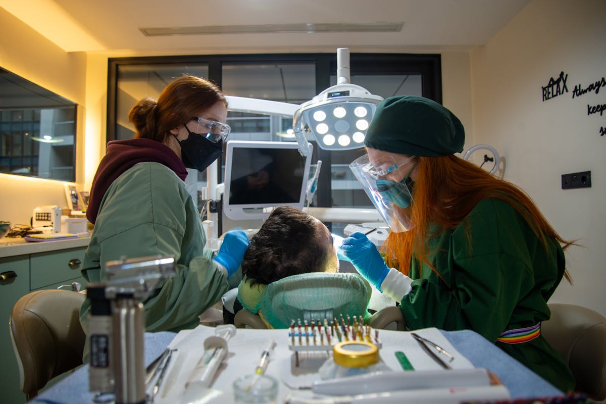 Dentists Treating a Male Patient at a Clinic