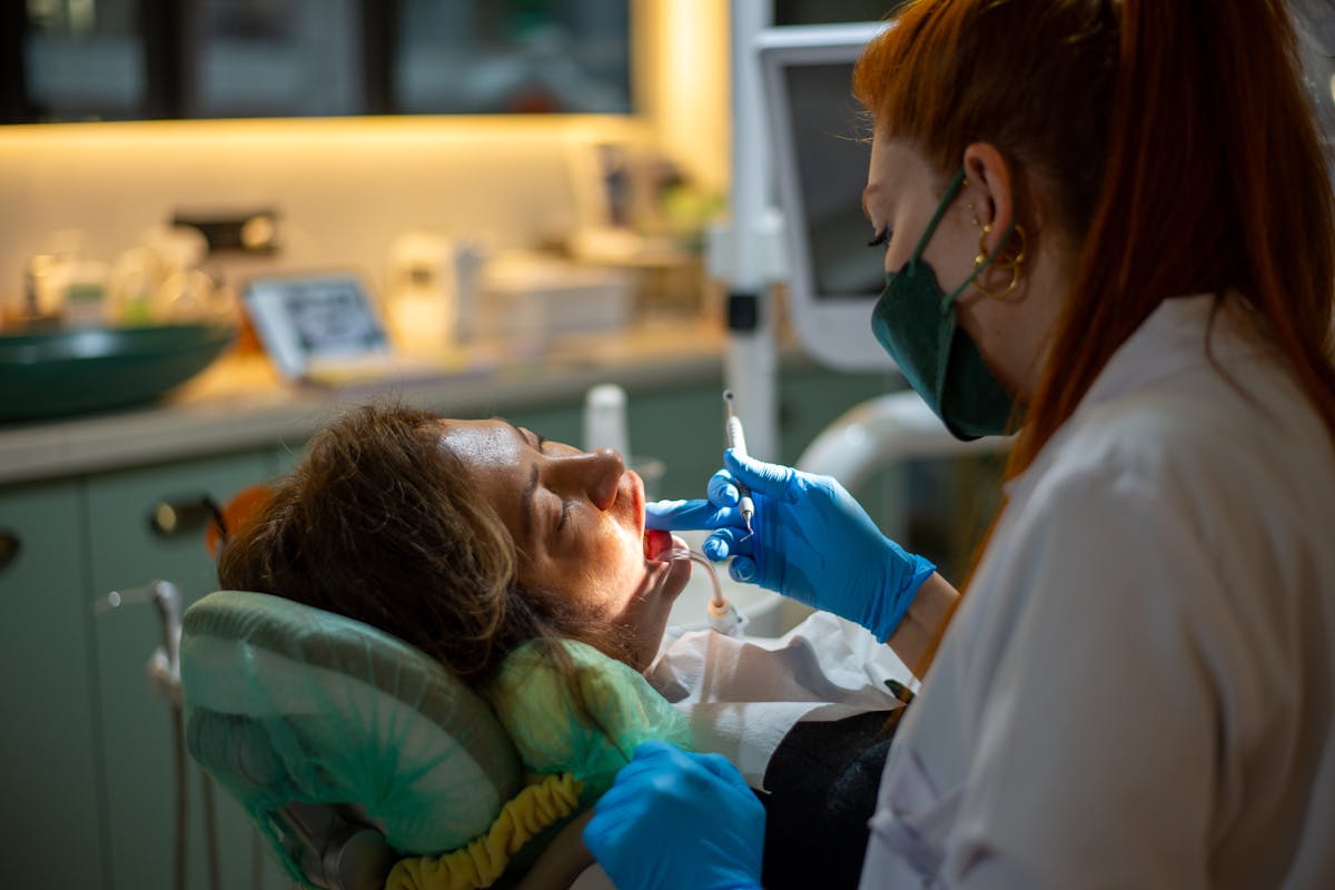 Dentist in Mask and Patient behind