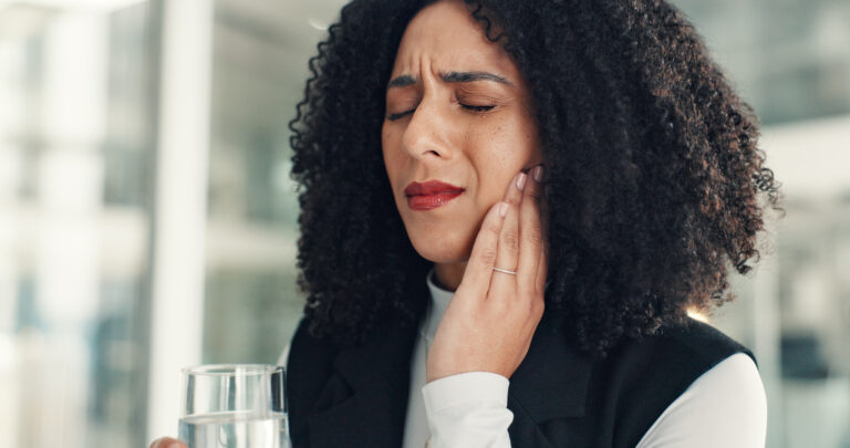 Water, business and woman in office with toothache, oral discomfort or inflammation in mouth. Cavity, gum disease and female person in workplace with tmj pain, teeth sensitivity and dental injury